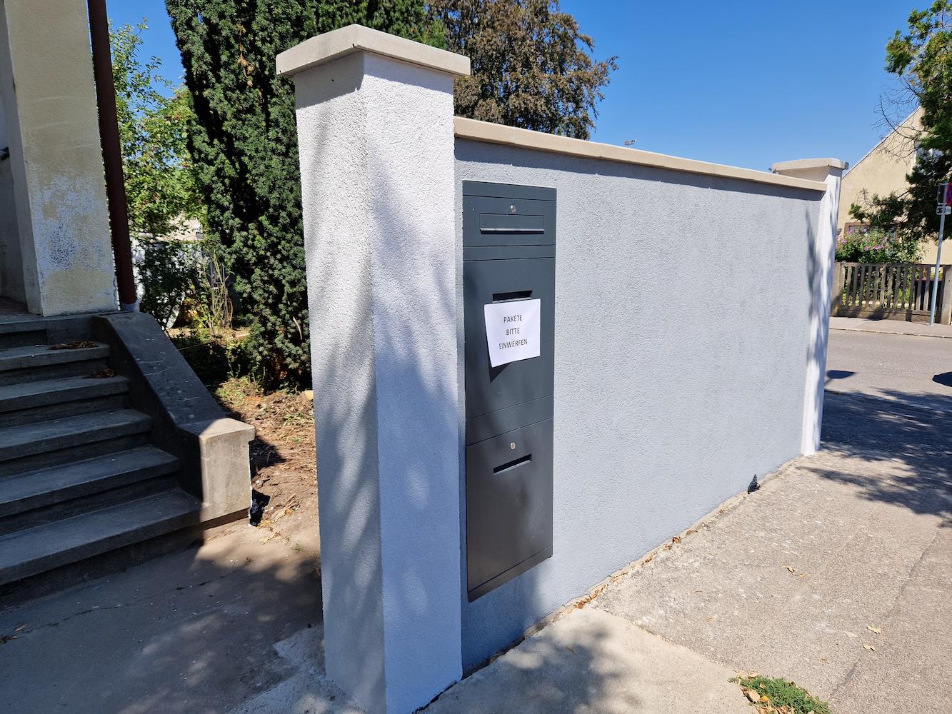 Fertiggstellte Einfriedungsmauer mit eingemauerten Briefkasten